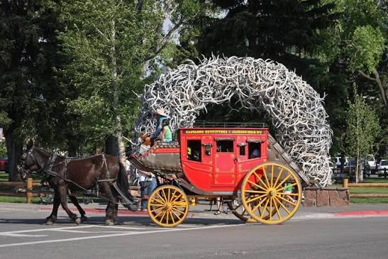Horse-drawn stagecoach passing through the antler arch Town Square in Jackson Hole